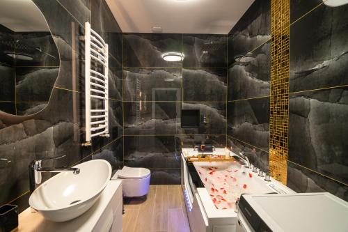 a bathroom with a black and white wall at NWK Apartments & SPA in Lidzbark