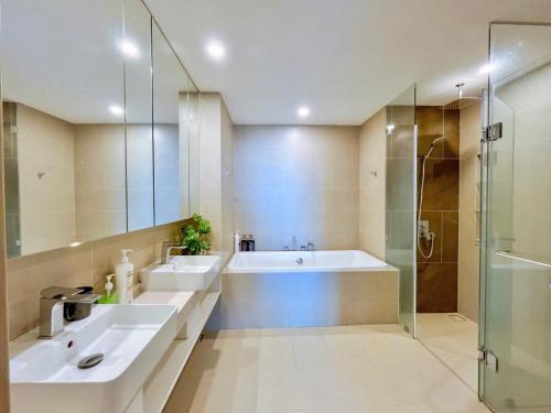 une salle de bain avec deux lavabos et une douche dans l'établissement The Sóng Apartment Vũng Tàu-RUBYVILLA, à Vung Tau