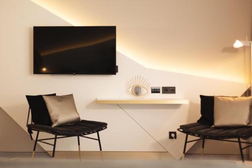 two chairs in a room with a television on a wall at Holiday Inn - the niu, Coin Frankfurt Ostend by IHG in Frankfurt/Main