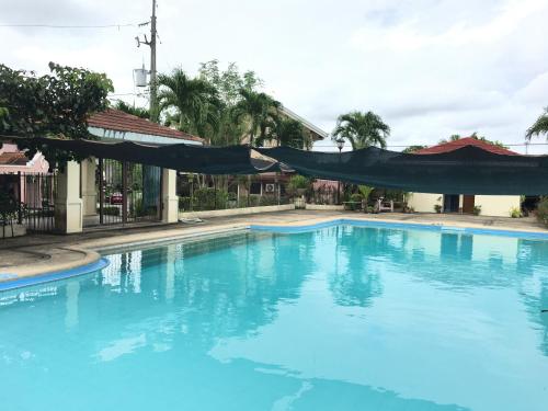 a large blue swimming pool with a black tarp over it at Eagle Ridge Family Vacation House in General Trias