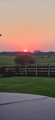 a sunset over a pasture with a fence and a field at ŻurawZdory 107 in Zdory