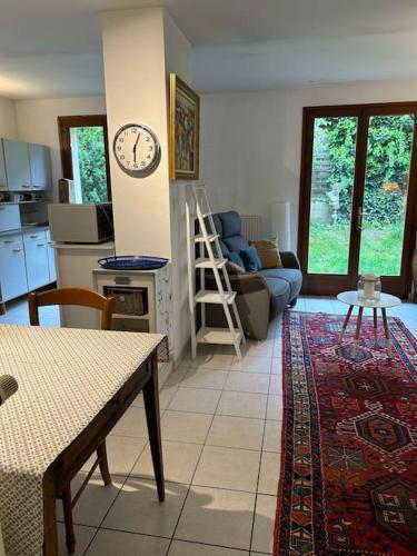 un salon avec une horloge murale dans l'établissement Eden un jardin au cœur du vieux village, à Fontaine-lès-Dijon