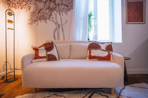 - un salon avec un canapé et des oreillers dans l'établissement Le Terra Rosa - Un séjour tout en douceur - WIFI, à Châteauroux