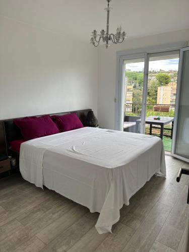 ein Schlafzimmer mit einem großen weißen Bett mit einem Fenster in der Unterkunft 3p cosy vue mer in Nizza