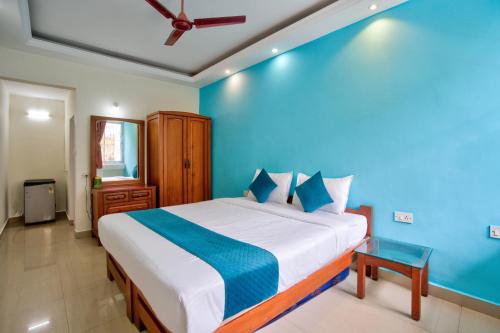 a bedroom with a large bed with a blue wall at Vaddo 15 in Aguada