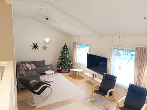 a living room with a christmas tree and a couch at House between pines 5-bedroom house with 3 toilets in Rovaniemi