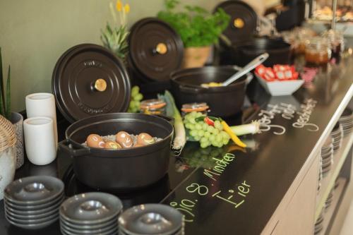 a counter top with pots and pans and vegetables on it at Holiday Inn - the niu, Mill Cologne Mülheim by IHG in Cologne