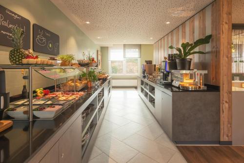 a large kitchen with a buffet of food on display at Holiday Inn - the niu, Mill Cologne Mülheim by IHG in Cologne