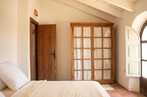 a bedroom with a bed and an open door at Finca Luca Oliva in Zahara de la Sierra