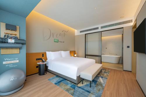 a hotel room with a bed and a bath tub at EVEN Suzhou Grand Canal by IHG in Suzhou