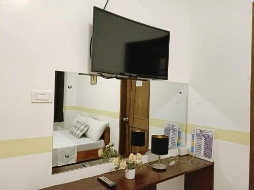 a living room with a tv on a wall at Villa Monica Hotel in Balatero