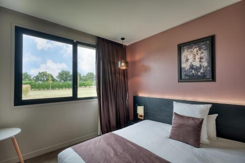 a hotel room with a bed and a window at Hôtel & Restaurant La maison des blés in Boutervilliers