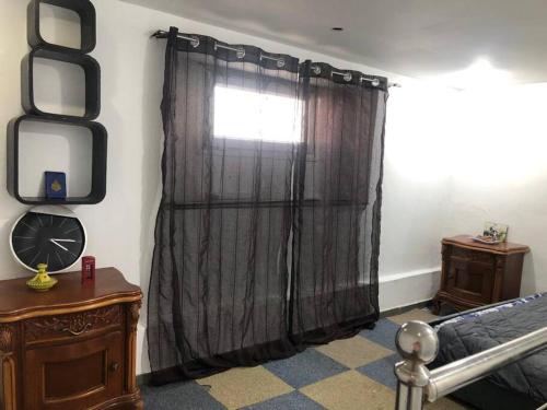 a bedroom with a black curtain and a window at Studio Cheraga center in Cheraga