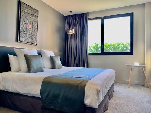 a bedroom with a large bed and a window at Hôtel & Restaurant La maison des blés in Boutervilliers
