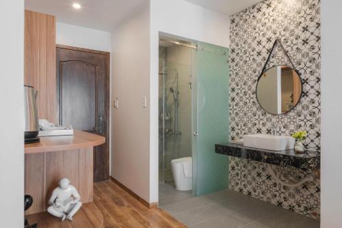 a bathroom with a sink and a mirror on a wall at Nature Hotel - Nam Ky Khoi Nghia in Da Lat