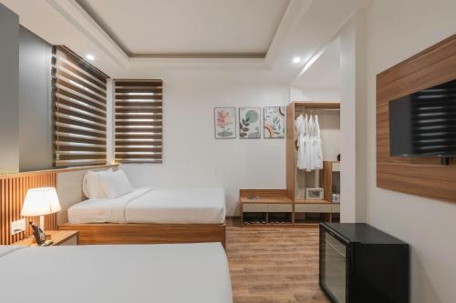 a bedroom with a bed and a tv in a room at Nature Hotel - Nam Ky Khoi Nghia in Da Lat