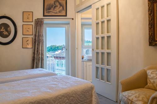 a bedroom with a bed and a large window at Ai Leoni Ruggenti - Suite dei Tesori Antichi in Monferrato in Ottiglio