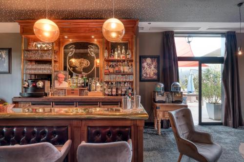 a bar in a restaurant with two chairs at Hôtel & Restaurant La maison des blés in Boutervilliers