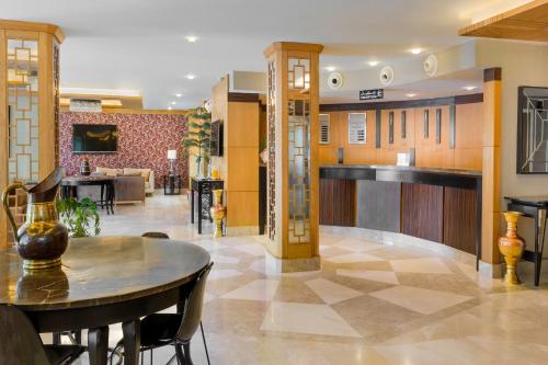 a lobby with a table and chairs and a bar at Hotel & Restaurant Sétif in Sétif