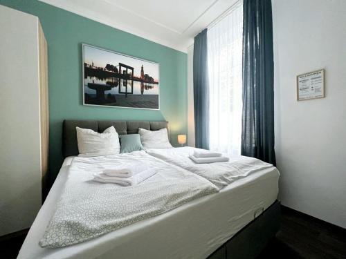 a bedroom with a large white bed with a window at Ferienwohnungen an der Weser in Bremerhaven