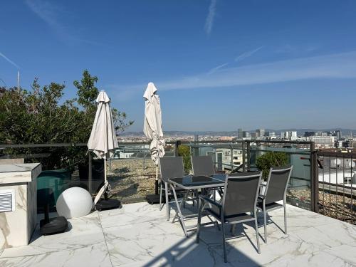 a patio with a table and chairs and an umbrella at Panorama Apartments Vienna in Vienna