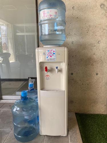 a refrigerator with a bottle of water on top of it at ゲストハウスUYokinawa in Uruma