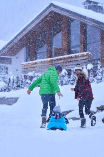 deux personnes jouant avec un enfant dans la neige dans l'établissement Chalet Rytola, modern & central chalet in Chamonix, à Chamonix-Mont-Blanc