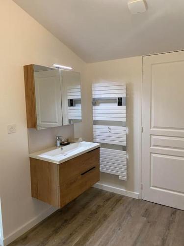 une salle de bain avec un lavabo et un miroir dans l'établissement Maison - Brissac Quincé Centre, à Brissac-Quincé