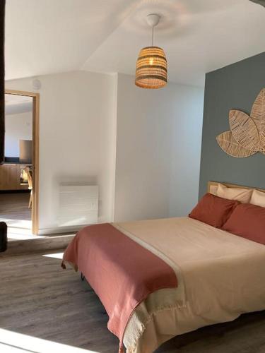 une chambre avec un lit et un lustre dans l'établissement Maison - Brissac Quincé Centre, à Brissac-Quincé