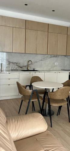 a kitchen with a table and chairs and a sink at New apartment in Gramsh