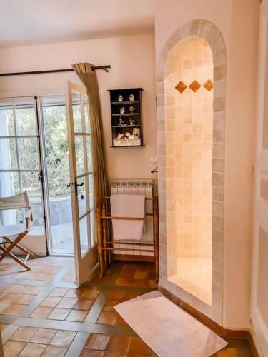 une salle de bain avec une douche avec une porte vitrée dans l'établissement La Villa Mandragore, à Saint-Tropez