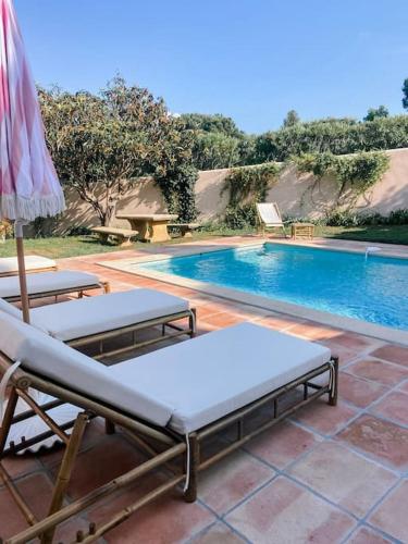 - 2 lits et un parasol à côté de la piscine dans l'établissement La Villa Mandragore, à Saint-Tropez