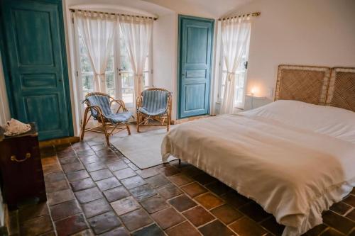 - une chambre avec un lit, 2 chaises et des fenêtres dans l'établissement La Villa Mandragore, à Saint-Tropez