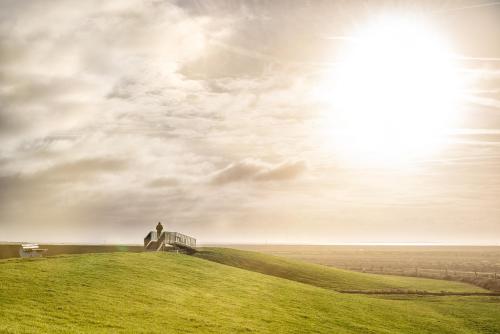 a person standing on top of a grassy hill at Spiekerhorst in Spiekeroog