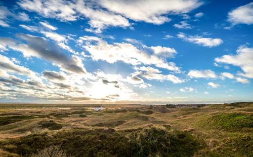 a view of the desert under a blue sky with clouds at Noorderpad 5 Boven Deck in Spiekeroog