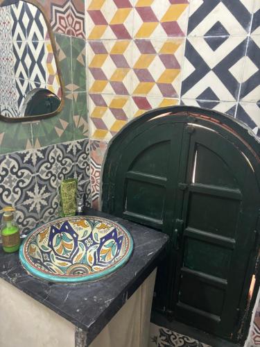 a bathroom with a sink and a plate on a counter at Riad Sanwa in Marrakech