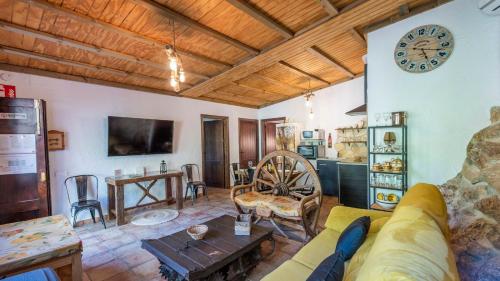 a living room with a couch and a clock on the wall at Casa de La Cascada Iznájar by Ruralidays in Iznájar