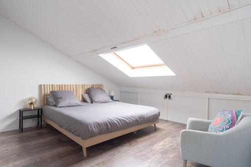 - une chambre avec un lit, un canapé et une lucarne dans l'établissement Grand Loft - Hypercentre - 7 pers, au Havre