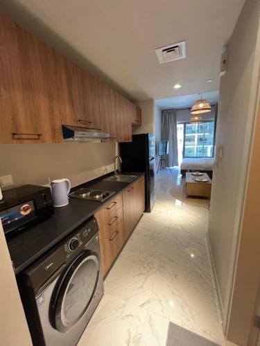 a kitchen with a washer and dryer in a room at The Chic Retreat, Stylish Studio Close to Yas & Airport in Abu Dhabi