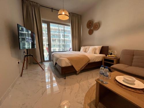 a bedroom with a bed and a tv and a couch at The Chic Retreat, Stylish Studio Close to Yas & Airport in Abu Dhabi