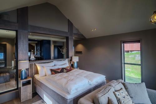 a bedroom with a large bed and a couch at Henningsvær Bryggehotell - by Classic Norway Hotels in Henningsvær