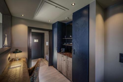 a dining room with a table and a blue wall at Henningsvær Bryggehotell - by Classic Norway Hotels in Henningsvær