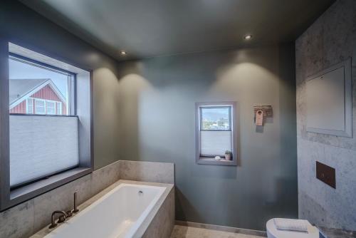 a bathroom with a tub and a window at Henningsvær Bryggehotell - by Classic Norway Hotels in Henningsvær