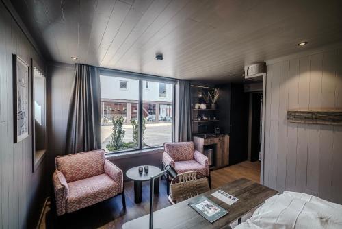 a living room with two chairs and a table at Henningsvær Bryggehotell - by Classic Norway Hotels in Henningsvær