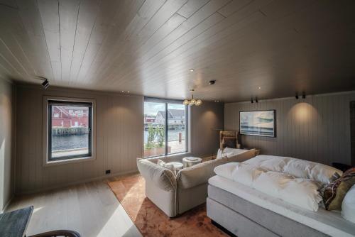 a living room with a white couch and a table at Henningsvær Bryggehotell - by Classic Norway Hotels in Henningsvær