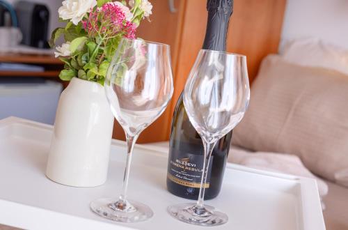 a bottle of wine and two wine glasses on a table at House Olive Garden Strunjan in Strunjan