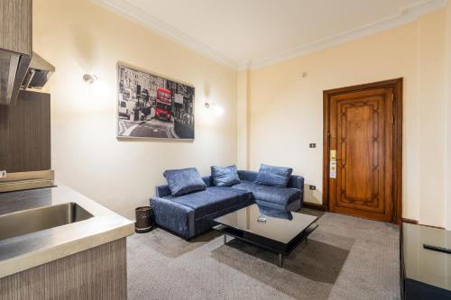 a living room with a blue couch and a table at Om Kolthoom Hotel in Cairo