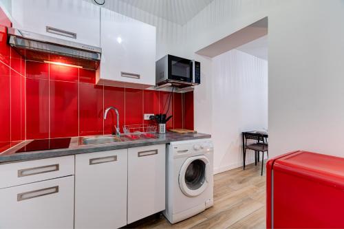 - une cuisine aux murs rouges et un lave-linge dans l'établissement Valrose - Wifi, AC, 2 pers, hyper centre, à Nice