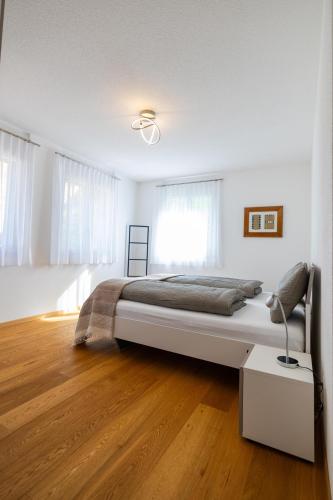 a bedroom with a large bed and a wooden floor at Apartments Residenz Iris in Leukerbad