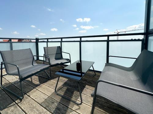 CityLoft - Augsburger Innenstadt-Bismarckviertel - kostenloser Tiefgaragenstellplatz في اوغسبورغ: ثلاثة كراسي وطاولة على شرفة